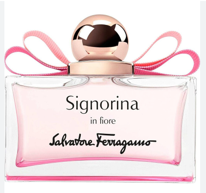 A bottle of Salvatore Ferragamo Signorina in fiore perfume, featuring a clear glass bottle filled with light pink liquid, a metallic rose gold cap, and a pink ribbon bow, set against a plain white background.