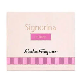 Signorina in fiore fragrance box by Salvatore Ferragamo, featuring a pale pink box with gold lettering, a pink rectangular label, and a pink striped band near the bottom.