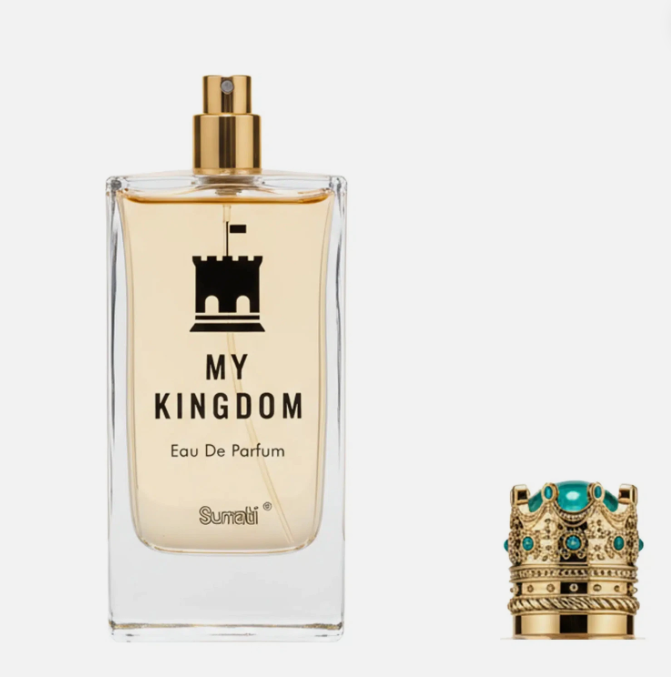A clear rectangular perfume bottle labeled 'MY KINGDOM' with a gold spray top, shown next to a decorative gold crown with turquoise stones on a light gray background.