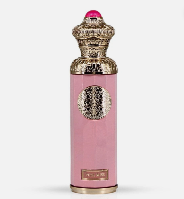 Pink cylindrical perfume bottle with ornate gold detailing, a pink gem on the cap, and a gold label reading 'PINK MISS' on a light gray background.