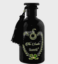 A black glass bottle with a black cap and a black tassel charm, featuring a green and white printed label that reads 'The Snake Surrati' with a snake emblem, on a light gray background.