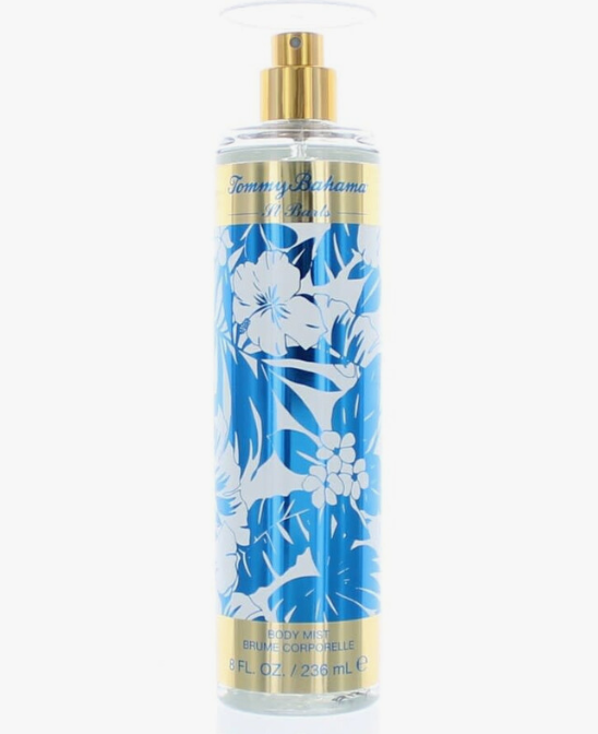 Tommy Bahama Set Sail St. Barts body mist in a clear cylindrical spray bottle with a gold pump, featuring a blue and white tropical floral pattern on a light gray background.