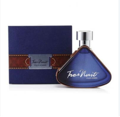 A bottle of Tres Nuit Pour Homme fragrance with a blue triangular glass bottle and silver cap, shown next to its dark blue box with a brown strap detail.
