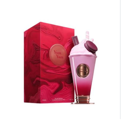 Yum Yum perfume bottle and packaging box. The bottle is shaped like a pink and red gradient milkshake cup with a white whipped cream top and a gold circular emblem.