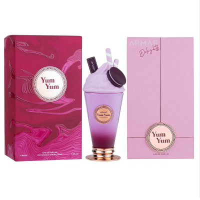 ARMAK Yum Yum perfume bottle and packaging on a white background. The bottle is shaped like a milkshake with purple gradient liquid, white whipped cream, a dark cookie, and a pink bunny ear.