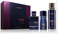 Al Haramain Dubai Night Perfume Gift Set featuring a dark purple and black box, a rectangular bottle, a cylindrical bottle, and a tall cylindrical bottle with a metallic cap, all on a reflective white surface.