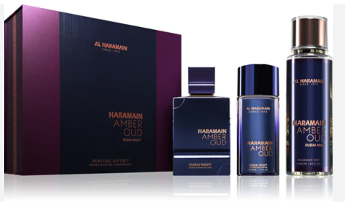 Al Haramain Dubai Night Perfume Gift Set featuring a dark purple and black box, a rectangular bottle, a cylindrical bottle, and a tall cylindrical bottle with a metallic cap, all on a reflective white surface.