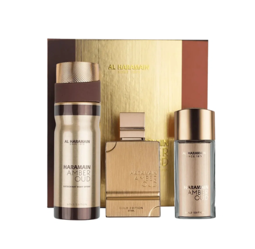 Al Haramain London Hairamain Amber Oud gift set featuring a gold and brown body spray bottle, a gold-toned spray bottle, a gold-toned rectangular perfume bottle, and a matching gold gift box on a white background.