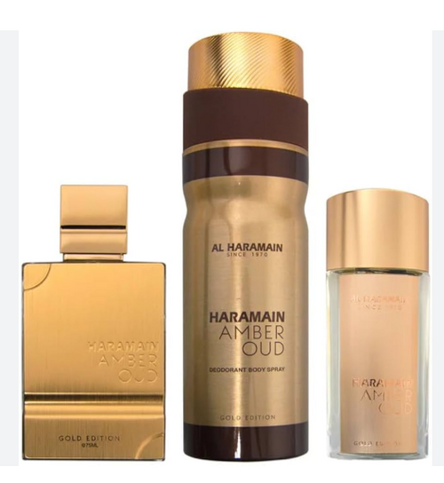 Al Haramain Amber Oud Gold Edition fragrance set, including a gold perfume bottle, a tall gold and brown body spray bottle, and a smaller clear bottle with a gold cap, on a white background.