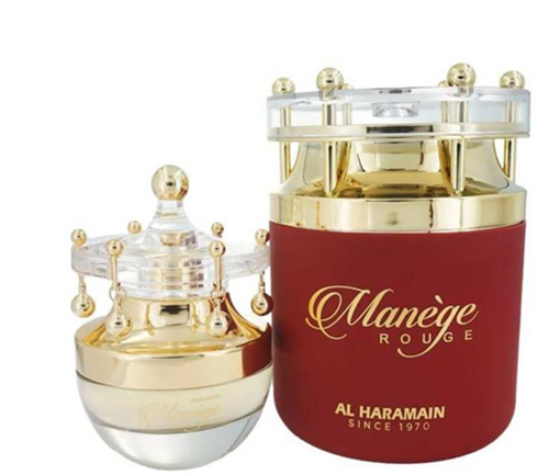 Al Haramain Manège Rouge perfume bottle and its outer display box, both featuring a deep red body with gold lettering and a clear glass crown-like cap with gold finials, on a white background.