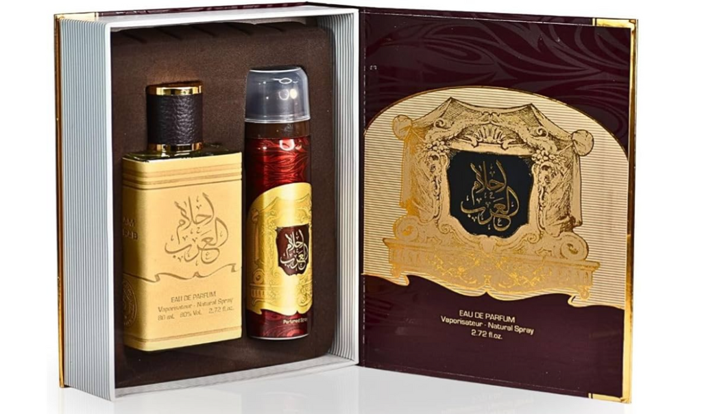 A luxury gift set containing a rectangular perfume bottle and an aerosol deodorant can, presented inside an ornate open box with a matching inner card. The packaging features gold Arabic calligraphy on a beige background, deep burgundy sections, and gold trim.