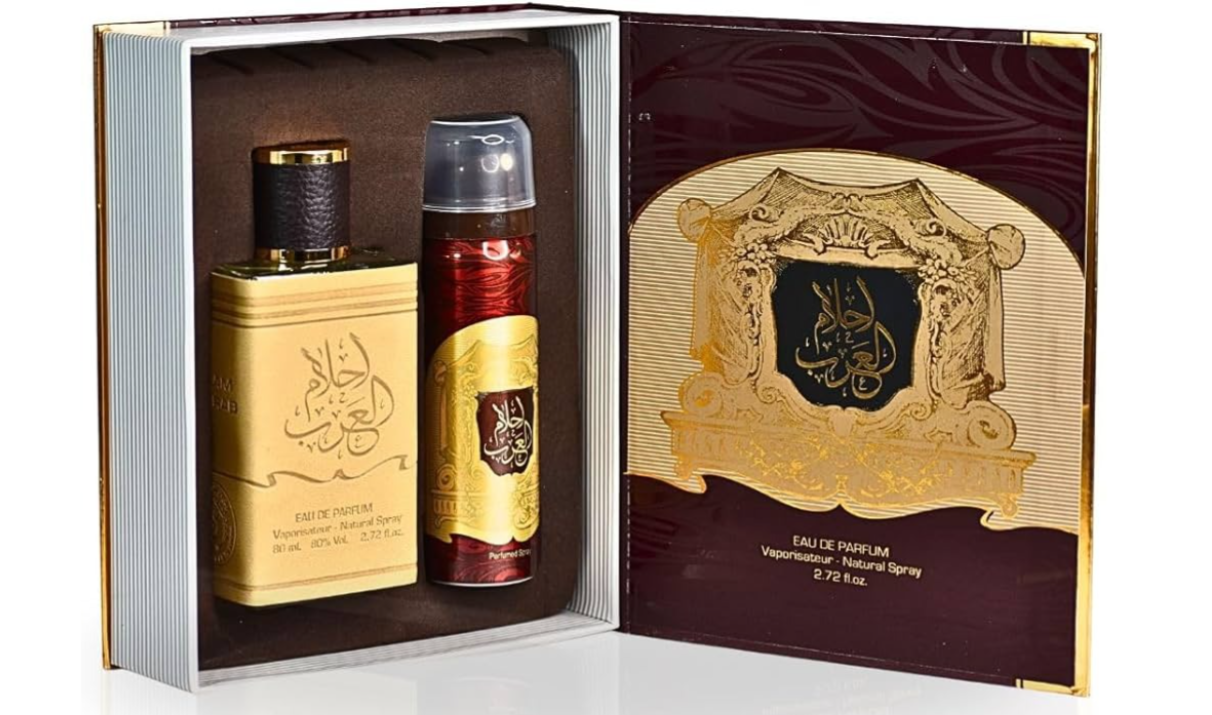 A luxury gift set containing a rectangular perfume bottle and an aerosol deodorant can, presented inside an ornate open box with a matching inner card. The packaging features gold Arabic calligraphy on a beige background, deep burgundy sections, and gold trim.