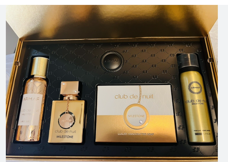 A luxury fragrance gift set from Armaf Club de Nuit Milestone, presented in a gold and black box. The set includes a 500ml bottle of Club de Nuit Intense, a 100ml bottle of Club de Nuit Milestone, a central branded box, and a 500ml can of Armaf Club de Nuit Mist White.