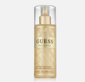 A bottle of GUESS BELLA VITA Shower Fragrance Mist in a champagne gold color with a clear cap and gold pump, set against a light gray background.