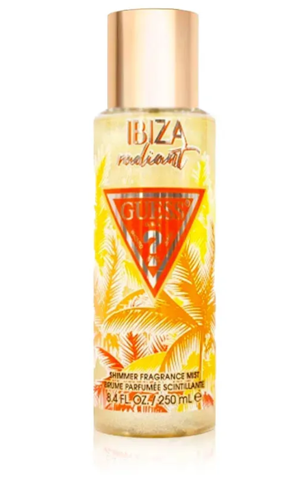 Guess 22 Ibiza Radiant Shimmer Fragrance Mist in a clear cylindrical bottle with a metallic rose gold cap, featuring a yellow and orange tropical palm tree design with a red Guess 22 logo.