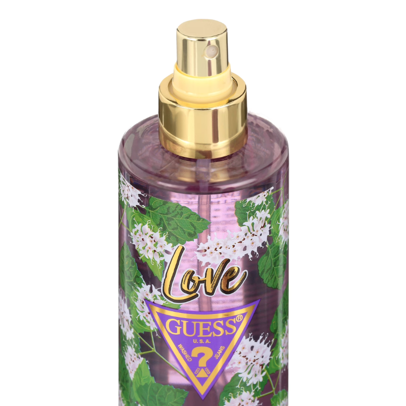 Guess Love Eau de Toilette spray bottle with a gold atomizer cap, featuring a purple and pink floral pattern with green leaves and white blossoms, and the Guess logo on the front.