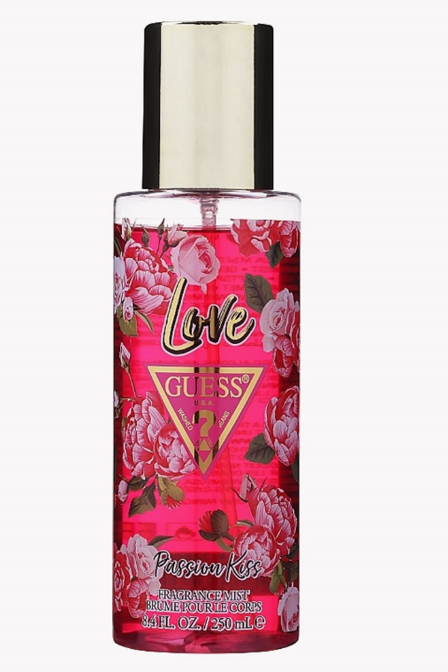 A bottle of GUESS Love Passion Kiss Fragrance Mist with a vibrant pink floral pattern and a metallic gold cap, set against a plain white background.