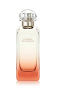 Hermes Un Jardin Sur La Lagune Eau de Parfum bottle with a clear glass body showing a peach to orange gradient, topped with a clear spherical cap and gold collar, on a white background.