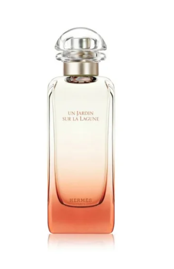Hermes Un Jardin Sur La Lagune Eau de Parfum bottle with a clear glass body showing a peach to orange gradient, topped with a clear spherical cap and gold collar, on a white background.