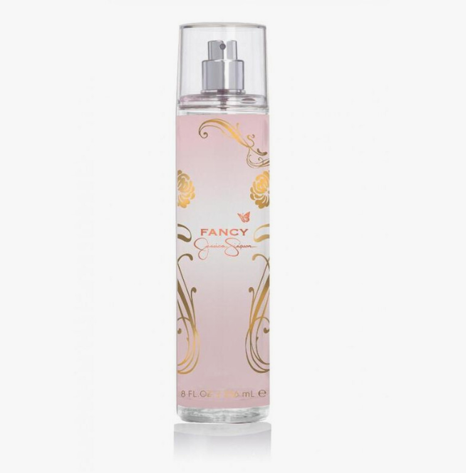 A tall cylindrical bottle of FANCY Eau de Parfum with a clear cap and a pale pink body decorated with gold floral and scroll designs, shown on a light gray background.