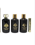 Three black perfume bottles with gold spade logos and gold caps, alongside a small gold travel spray vial, on a plain white background.