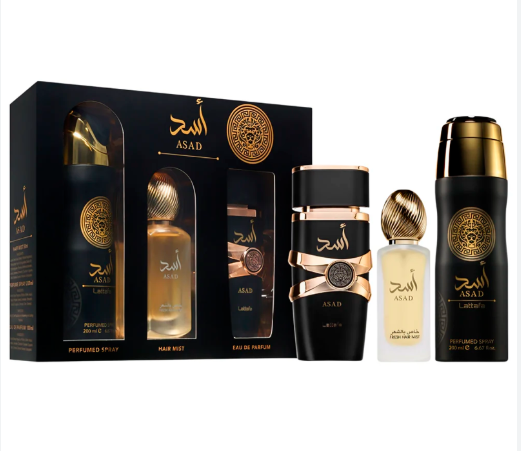A fragrance gift set from ASAD featuring a black presentation box and multiple bottles of perfume and hair mist on a plain white background. The bottles are black with gold caps, gold Arabic script, and some rose-gold metallic detailing.