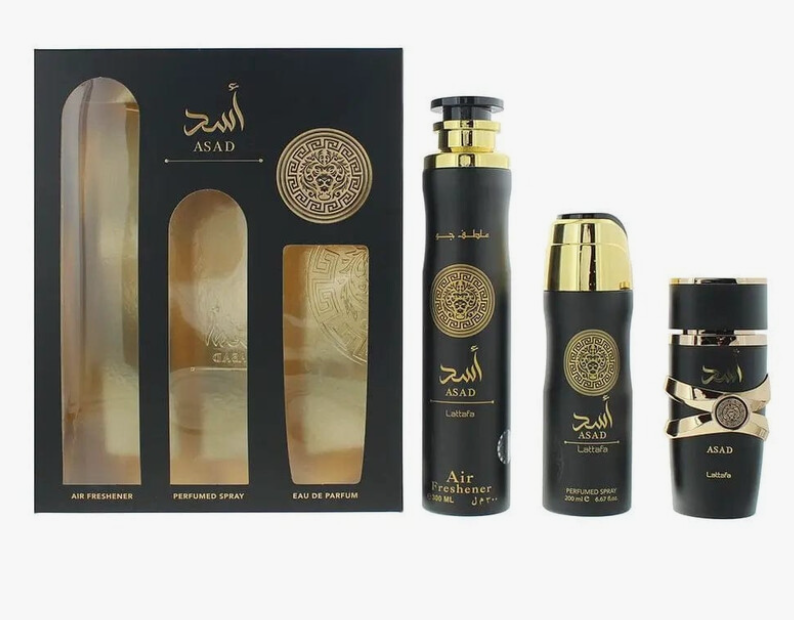 A 3-piece perfume gift set from Asad, featuring a black presentation box with gold detailing, a tall black air freshener bottle with gold accents, a medium black perfume spray bottle, and a small black travel perfume bottle, all on a white background.