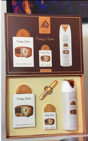 A boxed fragrance gift set labeled 'Vintage Radio' displayed open, showing multiple coordinated products including a large bottle, smaller bottles, and a cylindrical item on a cream insert inside a brown box.