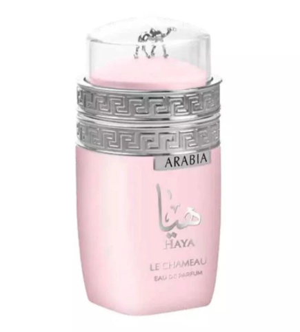 A bottle of Haya Arabia Le Chameau Eau de Parfum in a soft pastel pink color, featuring a silver Greek key pattern band and a clear cap with a small camel figurine.