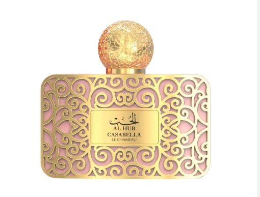 A luxury perfume bottle with an ornate gold filigree pattern, a pink background, and a spherical gold cap. The front label reads 'AL HUB CASABELLA LE CHAMEAU'.