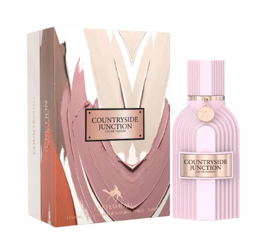 Countryside Junction Eau de Parfum bottle and its matching outer packaging box, featuring a light pink ribbed bottle and box with abstract brushstroke patterns in beige, pink, and terracotta.
