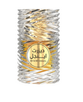 A cylindrical glass perfume bottle with a textured, ribbed clear glass body and a gold circular label in the center. The label features Arabic text and the brand name 'DESERT ANGEL'.