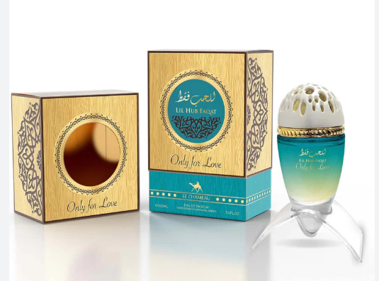 A perfume bottle and its decorative packaging boxes on a clean white background. The bottle has a teal-to-yellow gradient glass body with a white perforated cap, and the boxes are gold with turquoise accents and Arabic text reading 'Only for Love'.
