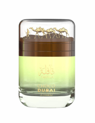 Chocolat Dubai Elixir perfume bottle with a clear glass body, light green and amber liquid, gold lettering, and a gold camel motif on the lid, set against a plain white background.