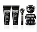 Moschino Toy Boy fragrance gift set featuring a black bear-shaped perfume bottle, a black tube, and a black spray bottle with white text on a white background.