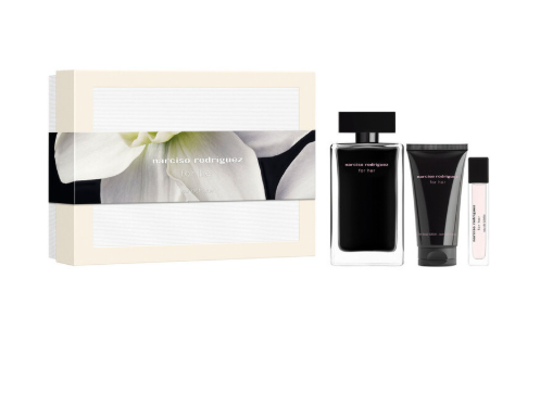 Nicnica Rodriguez For Her gift set featuring a cream-colored box with a white flower design, a large black perfume bottle, a black body wash tube, and a small travel spray vial on a solid white background.