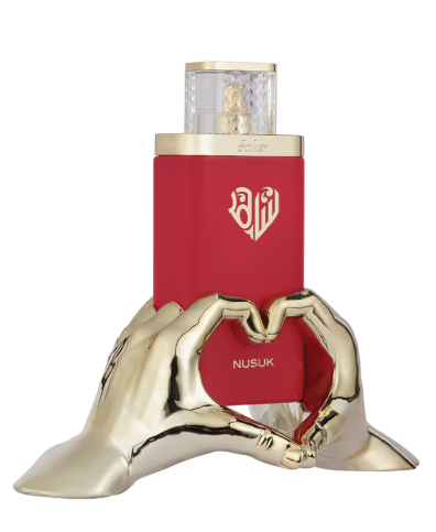 Nusuk perfume bottle in red with gold accents, displayed on a sculptural gold hand base against a white background.