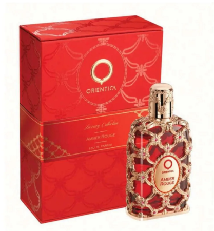 Orientica Ambri Rouge perfume bottle with ornate gold filigree and red liquid, displayed next to its matching red and gold presentation box on a white background.