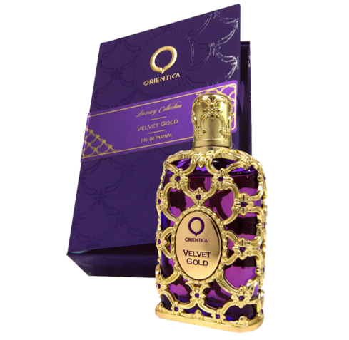 Orientalia Velvet Gold Eau de Parfum bottle with ornate gold filigree and a purple glass body, shown in front of its matching purple and gold retail box on a white background.
