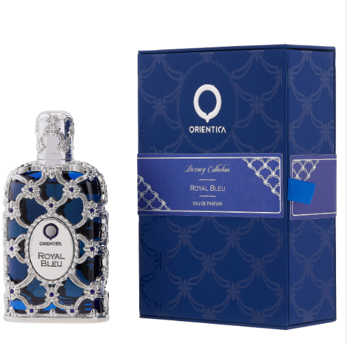 Orientika Royal Bleu Eau de Parfum bottle with ornate silver filigree and blue liquid, shown next to its blue patterned packaging box.
